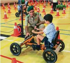  ?? Courtesy: Dubai Police ?? Col. Jamal Al Bannai, Acting Director of Traffic Department, Dubai Police, offers guidance to a youngster as part of the ‘My First Licence — I Know My Road Rules’ programme.