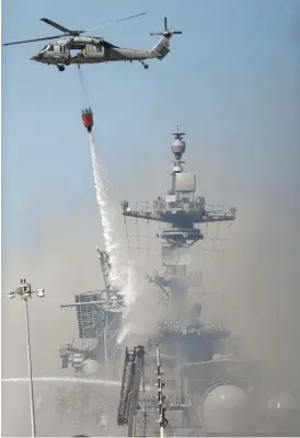  ?? GREGORY BULL/AP ?? A helicopter drops water on the USS Bonhomme Richard on Monday in San Diego.