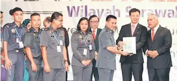  ??  ?? Chua (second right) presenting the Gold Award to team Taiton of Sarawak Region Bomba and Rescue Academy. Also seen is Abdul Latif (right). – Photos by Chimon Upon.