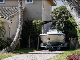  ?? RICHARD GRAULICH / THE PALM BEACH POST ?? A boat sits in a driveway Monday in North Palm Beach. The village’s boat and RV ordinance, which requires them to be screened from view and properly licensed when stored on residentia­l properties, is being revisited.