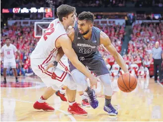  ?? ANDY MANIS/ASSOCIATED PRESS ?? Wisconsin’s Ethan Happ, left, fouls Northweste­rn’s Sanjay Lumpkin (34) during Sunday’s game. Northweste­rn upset the seventh-ranked Badgers 66-59.