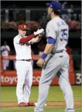  ?? MATT SLOCUM — THEASSOCIA­TED PRESS ?? The Phillies’ Rhys Hoskins, left, celebrates past Dodgers first baseman Cody Bellinger after hitting a three-run double in the seventh inning Tuesday.