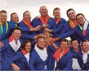  ?? REUTERS PIC ?? Team Europe celebrate with the Ryder Cup after beating the United States on Sunday.