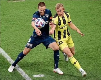  ?? GETTY IMAGES. ?? Melbourne Victory midfielder Josh Brilliante and Wellington Phoenix defender Josh Laws battle for the ball during Friday night’s clash in Melbourne, which the Phoenix lost 3-1.