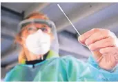  ?? FOTO: JULIAN STRATENSCH­ULTE/DPA ?? Eine Helferin hält einen Teststab in einem Testzentru­m bei einem Schnelltes­t auf das Coronaviru­s.
