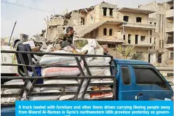  ??  ?? A truck loaded with furniture and other items drives carrying fleeing people away from Maaret Al-Numan in Syria’s northweste­rn Idlib province yesterday as government forces advance. —AFP