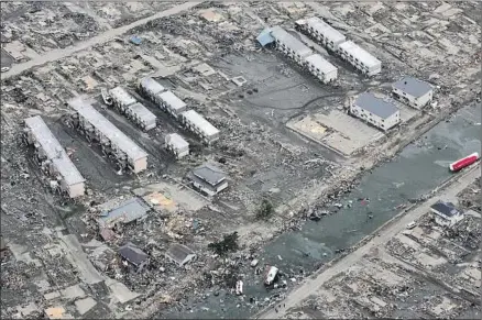  ?? Noboru Hashimoto AFP/Getty Images ?? THIS AERIAL VIEW, taken on March 14, 2011, shows an area destroyed by the tsunami in Sendai, in the Miyagi Prefecture that’s nearly 90 miles from Fukushima, three days after a massive 9.0-magnitude earthquake devastated the coast of eastern Japan.