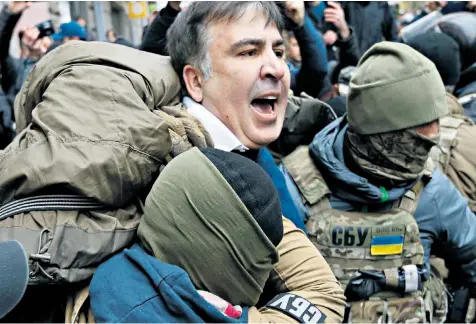  ??  ?? Supporters of Mikheil Saakashvil­i spirit away the former Georgian president, above, and fight with police, right