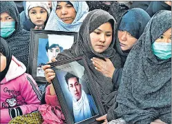  ?? AFP ?? Protesters from the Hazara community mourn with photos of attack victims near Quetta.
