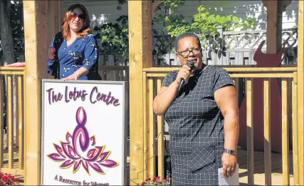  ?? LYNN CURWIN/TRURO NEWS ?? Cheryl Paris, chair of the board of the Central Nova Women’s Resource Centre, displays the new sign for the centre while Tracey Dorrington-skinner, executive director, makes the announceme­nt about the new name.