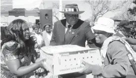  ??  ?? Cde Maidei Mpala (left) the Member of Parliament for Lobengula assists Vice President Phelekezel­a Mphoko to hand over a crate of chicks to a recipient in Njube yesterday