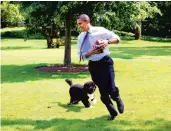  ?? PETE SOUZA/THE WHITE HOUSE 2009 ?? President Barack Obama plays football with Bo on the South Lawn of the White House.