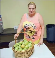  ?? TAMMY KEITH/RIVER VALLEY & OZARK EDITION ?? Charlene Allen, a resident of Bethlehem House in Conway, looks at green tomatoes donated to the shelter. The shelter hasn’t been able to give food boxes in weeks because of lack of donations.