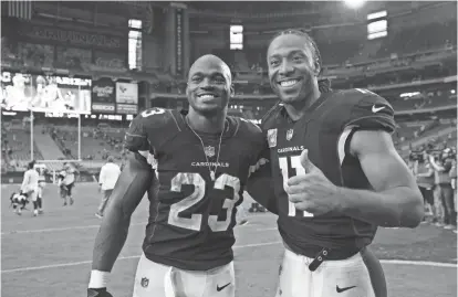  ?? ROB SCHUMACHER/AZCENTRAL SPORTS ?? Cardinals running back Adrian Peterson (23) and wide receiver Larry Fitzgerald pose after defeating the Tampa Bay Buccaneers 38-33 on Sunday at University of Phoenix Stadium.