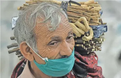  ?? Picture: AFP ?? A (teeth cleaning twig) street vendor looks for customers along a street in Lahore, Pakistan yesterday.