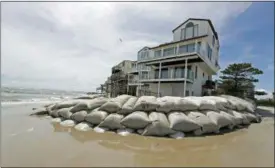  ?? CHUCK BURTON — THE ASSOCIATED PRESS ?? Sand bags surround homes on North Topsail Beach, N.C., Wednesday as Hurricane Florence threatens the coast.