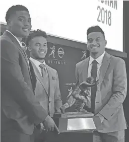  ??  ?? Heisman Trophy finalists, from left, Ohio State’s Dwayne Haskins, Oklahoma’s Kyler Murray and Alabama’s Tua Tagovailoa pose with the Heisman Trophy at the New York Stock Exchange on Friday in New York.