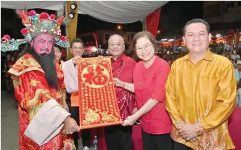  ?? ?? Liew (second right) receiving a festive scroll from Goh (on her right) and the God of Fortune (left). At right is Tan.