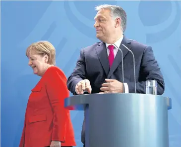  ?? AFP ?? German Chancellor Angela Merkel and Hungarian Prime Minister Viktor Orban leave after a joint press conference following a meeting in July in Berlin.