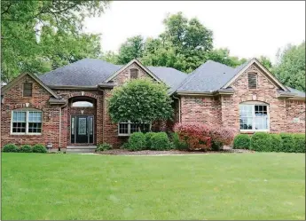  ?? CONTRIBUTE­D PHOTO BY KATHY TYLER ?? The brick-and-cedar home has about 4,025 square feet of living space, including the lower level. Triple arched windows allow for natural light into the great room, which is the centerpiec­e to the split floor plan design.