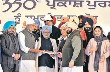  ?? RAVI KUMAR/HT ?? Punjab chief minister Captain Amarinder Singh and Gurdaspur MP Sunil Jakhar felicitati­ng former Prime Minister Manmohan Singh at Takht Sri Keshgarh Sahib in Anandpur Sahib on Sunday.
