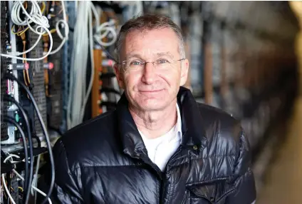  ?? AP FOTO ?? BITCOIN MINING. In this photo taken on Jan. 17, 2018, Helmut Rauth, the director of Genesis Mining poses for a portrait next to a row of computer rigs that run around the clock ‘mining’ bitcoin in Keflavik, Iceland. Hand in hand with the rise of...