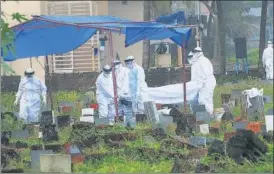  ?? PTI ?? Health workers bury the body of a 12-year-old boy who died of Nipah virus at the Kannampara­mbu cemetery in Kozhikode on Sunday.