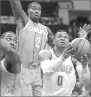  ?? AP/CHUCK BURTON ?? Oklahoma City's Russell Westbrook (0) drives past Charlotte Hornets' Marvin Williams (2) and Michael Kidd-Gilchrist on Saturday in Charlotte, N.C.