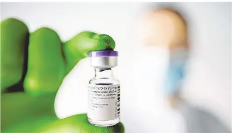  ?? FOTO: BIONTECH SE/DPA ?? Ein Mitarbeite­r des Mainzer Unternehme­ns Biontech hält ein Fläschen mit dem neuen Corona-Impfstoff in der Hand.