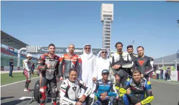  ??  ?? HE the Minister for Sport and Culture Salah bin Ghanem bin Nasser al-Ali and Kuwaiti ambassador in Qatar Hafeez Mohamed al-Ajmi pose with riders at the Losail Internatio­nal Circuit.