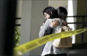  ?? ASSOCIATED PRESS ?? Mourners embrace outside of the Thousand Oaks Teen Center, where relatives and friends gathered in the aftermath of a mass shooting, Thursday in Thousand Oaks, Calif. Multiple people were shot and killed late Wednesday by a gunman who opened fire at the Borderline Bar &amp; Grill, which was holding a weekly country music dance night for college students.