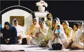  ??  ?? The Sodhi family hold a Sikh prayer service Wednesday prior to the service.