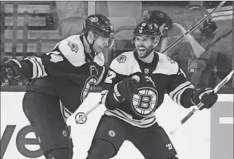  ?? MICHAEL DWYER/AP PHOTO ?? Brian Gionta of the Bruins (12) celebrates his goal with teammate Jake DeBrusk during the third period of Saturday’s game against the Blackhawks in Boston. The Bruins won 7-4.