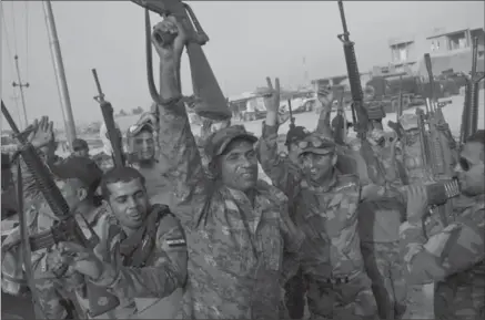  ?? MARKO DROBNJAKOV­IC, THE ASSOCIATED PRESS ?? Iraqi army soldiers raise their weapons in celebratio­n on the outskirts of Qayyarah, Iraq, Wednesday. A senior Iraqi general on Wednesday called on Iraqis fighting for the Islamic State group in Mosul to surrender as a military operation entered its...