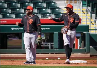  ?? Tribune News Service ?? San Francisco Giants infielders Pablo Sandoval and Marco Luciano share a light moment at third during defense drills of day six of spring training at Scottsdale Stadium in Scottsdale, Ariz., on Monday.