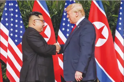  ?? AP PHOTO ?? U.S. President Donald Trump shakes hands with North Korea leader Kim Jong Un at the Capella resort on Sentosa Island on Tuesday in Singapore.