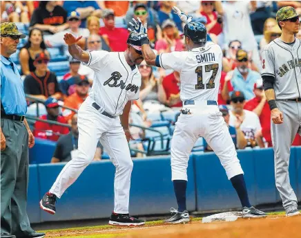  ?? ASSOCIATED PRESS PHOTOS ?? Atlanta’s Mallex Smith celebrates with third-base coach Bo Porter after Smith hit a three-run triple during the second inning of Monday’s game against San Francisco. The Braves beat the Giants 5-3.