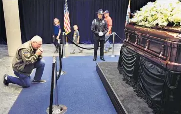  ??  ?? STEVEN LESLIE kneels in prayer in front of Nancy Reagan’s casket. The former f irst lady had planned her own funeral down to the last detail, including the guest list and the location of her interment.