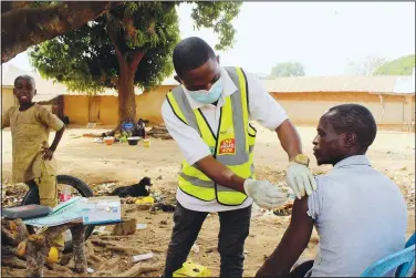  ?? ?? Bawa gives a man the AstraZenec­a covid-19 vaccine in Sabon Kuje.