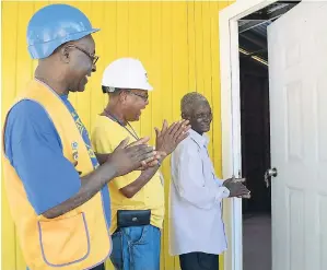  ?? CONTRIBUTE­D PHOTOS ?? It was a happy moment for 76-year-old Malcolm Green (right) as he opened the door to his new home moments after receiving the keys from Patrick Porter (left), president of the Portmore Lions Club, and Spencer Reynolds, senior field officer at Food For...