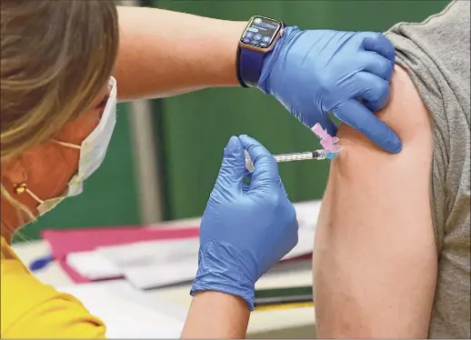  ?? Photos by Lori Van Buren / Times Union ?? Registered nurse Kristen Hallett administer­s freshman Colin Ingraham’s first Pfizer COVID-19 vaccine at Siena College on Tuesday in Loudonvill­e. Five hundred Siena students preregiste­red for the clinic.