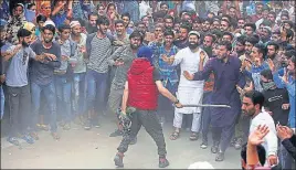  ?? REUTERS ?? A suspected militant keeps people away before offering a gun salute during the funeral of Bilal Ahmed, a suspected militant, who was killed in an encounter with security forces in Kulgam district.