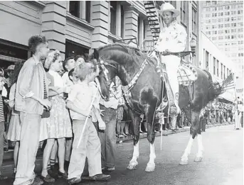  ??  ?? Gene Autry and his horse entertain children during the 1947 Houston Fat Stock Show and Rodeo parade. Five years earlier, he was the first celebrity hired to perform at the rodeo.