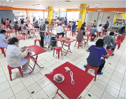  ?? PATTARAPON­G CHATPATTAR­ASILL ?? Tables at a food centre in Soi Lalai Sap in Bang Rak district are arranged far apart from one another to comply with Covid-19 control measures. Only one patron is allowed at each table.