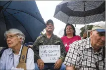  ?? AMANDA VOISARD / AMERICAN-STATESMAN ?? Ruben Yzaguirre (center) attends a vigil and prayer walk earlier this month at Archer Park in McAllen. Participan­ts honored immigrant families separated at the border.
