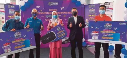  ?? PIC By ASYRAF HAMZAH ?? PTPTN chief executive officer Ahmad Dasuki Abdul Majid (second from left) posing with the winners of the Cabutan WOW! SSPN-i Plus 2020, Muhammad Zulfadli Hadri Abdul Rahim (left), Sonita Sudin (centre) and Lim Kee Hau (right) at Bangsar NZ Wheels in Kuala Lumpur yesterday. With him is NZ Wheels Sdn Bhd Automotive Group chief executive officer Datuk Nik Hamdam Nik Hassan.