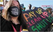  ?? —AFP ?? Asking for justice: A demonstrat­or holding a sign that reads ‘pay up clean up shut up’ during a protest at the COP27 UN Climate Summit.