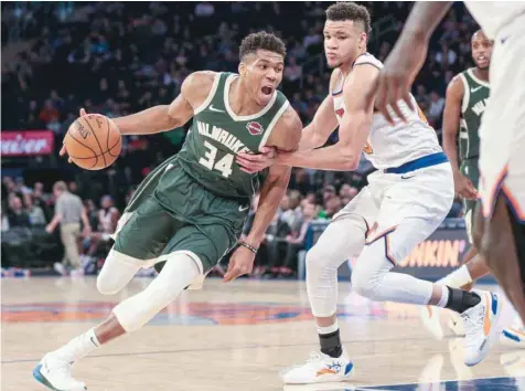  ?? — USA Today Sports ?? Milwaukee Bucks’ Giannis Antetokoun­mpo (34) drives the ball to the basket as New York Knicks forward Kevin Knox II (20) defends during the second half at Madison Square Garden.