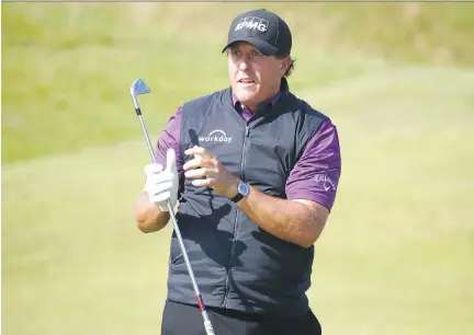  ?? GREGORY SHAMUS/GETTY IMAGES ?? Phil Mickelson, seen watching his approach shot during a practice round before the British Open at Royal Birkdale in Southport, England on Tuesday, says he’ll opt to use a three-wood instead of a driver given a lack of wind and the course’s tough links...