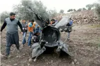  ?? AFP ?? People stand next to a part of a missile in Quneitra, Syria. —